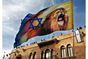 Từ mái một tòa nhà, những người dân (Israel) ở Jerusalem đứng theo dõi một cuộc diễu hành của phe Ki-tô cực đoan ủng hộ Israel; Một người tuần hành mang một lá cờ có hình ngôi sao David và một con sư tử Ảnh: AP/Kevin Frayer, 2006