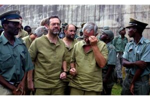 Cựu đại úy biệt kích SAS Simon Mann (đeo kính) bị bắt giam tại Zimbabwe. Ảnh từ trang này